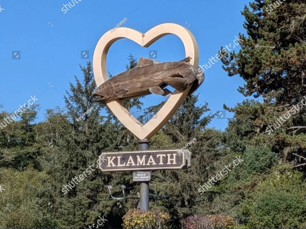 A driftwood heart sculpture framing a wooden sign for Klamath, California